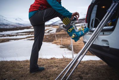Woman putting on backcountry ski boot in iceland