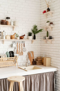 Rustic kitchen interior with brick wall and white wooden shelves