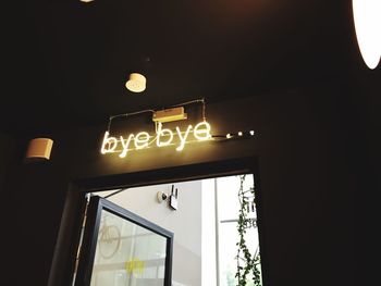 Low angle view of illuminated information sign at night