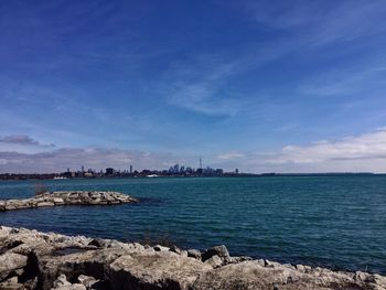 Distant view of city in lake ontario against sky