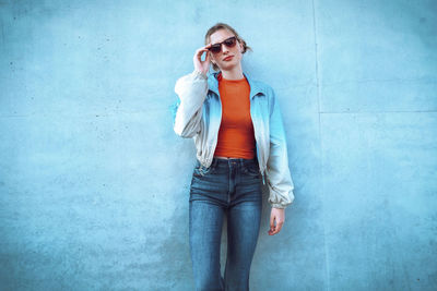 Young woman standing in front of blue wall