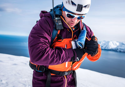 Man puts ski skins in his jacket pocket in iceland