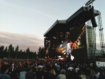 Crowd at music concert against sky