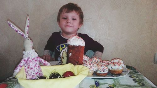 Portrait of boy with dessert on table during easter