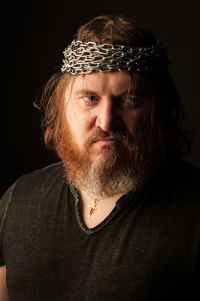 Portrait of man wearing hat against black background