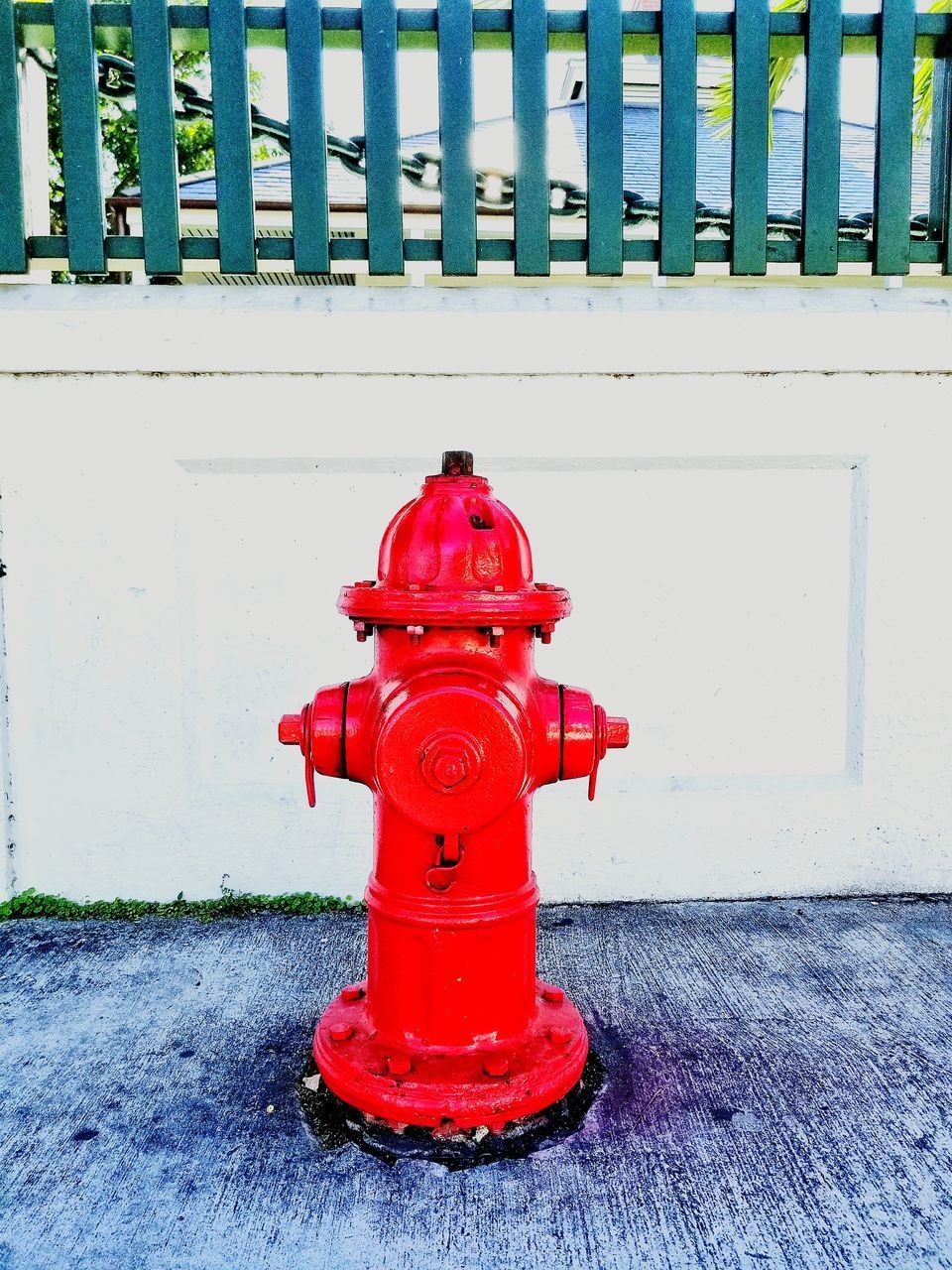 RED FIRE HYDRANT ON FOOTPATH BY WALL