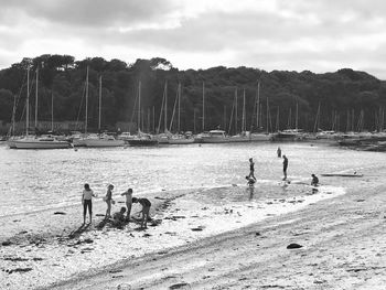 People enjoying on beach against sky