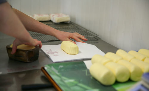 Close-up of hands wrapping butter