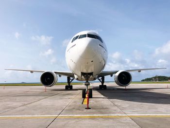 Airplane at runway against sky