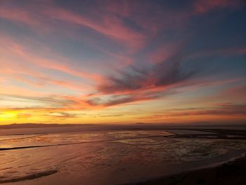 Scenic view of beach against romantic sky at sunset