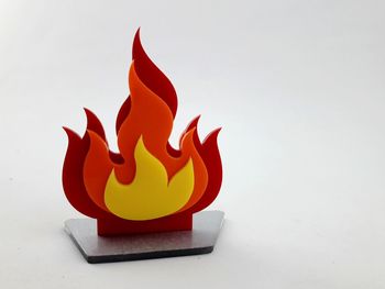 Close-up of orange design on table against white background