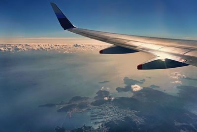 Airplane flying over landscape against sky