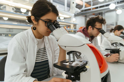 Laboratory technicians using microscopes in lab