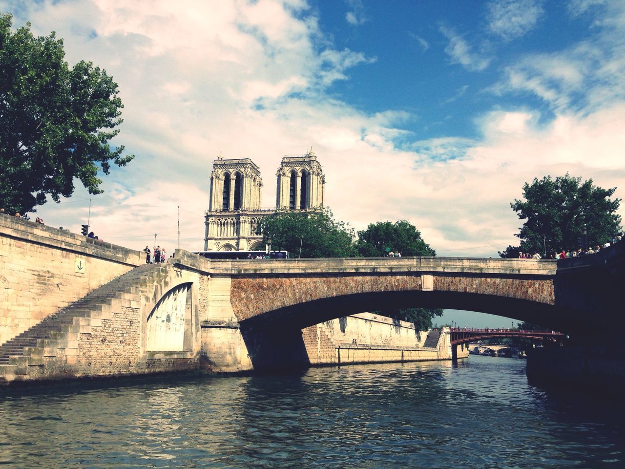 architecture, built structure, building exterior, sky, water, cloud - sky, river, connection, tree, bridge - man made structure, cloud, travel destinations, waterfront, city, arch, famous place, cloudy, place of worship, day, tower