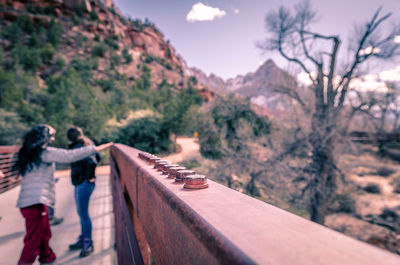 Rear view of people walking on mountain against sky