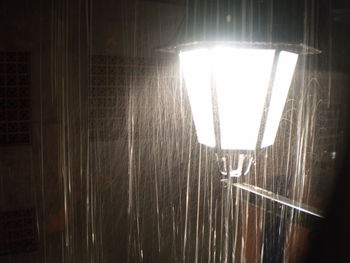 Close-up of illuminated lamp hanging on wall