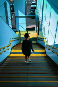 Rear view of woman walking on staircase