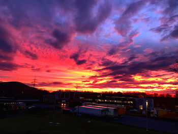 Silhouette buildings against dramatic sky during sunset