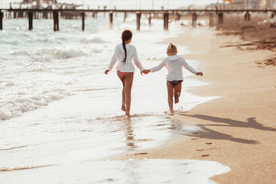 Rear view of woman walking at beach