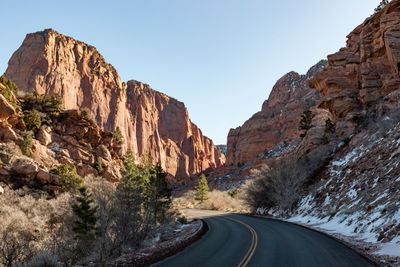 Road amidst rocks against clear sky