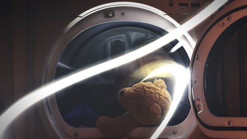 Close-up of teddy bear in washing machine by light painting