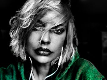 Close-up portrait of young woman against black background