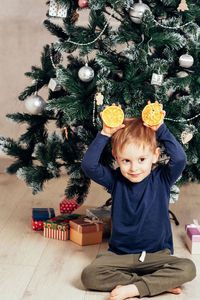 Portrait of cute girl playing with christmas tree