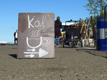 Information sign on street against clear blue sky