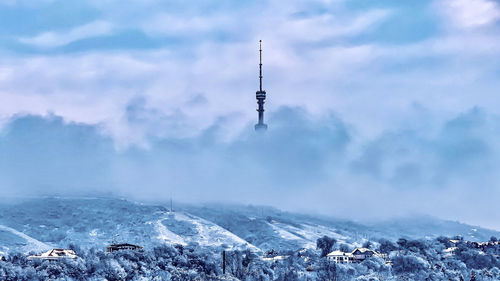 Communications tower against cloudy sky