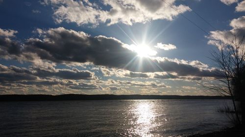 Sun shining through clouds over sea