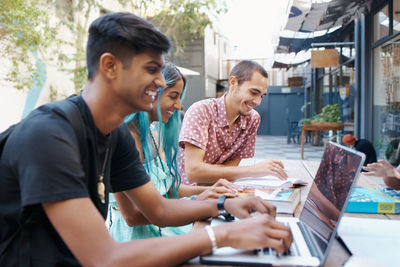 Smiling friends studying at campus