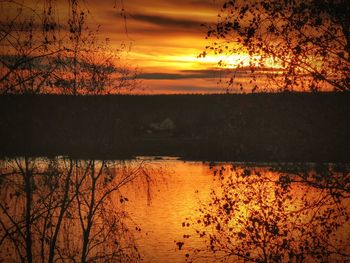 Scenic view of lake against orange sky