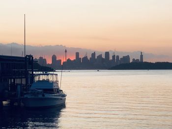Scenic view of sea by buildings against sky during sunset