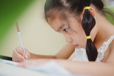 Close-up of girl sitting at home