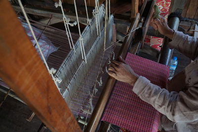 High angle view of person working on handloom