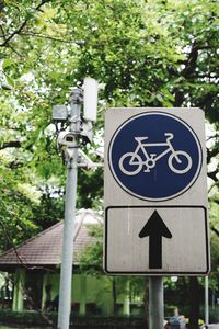Close-up of road sign against trees
