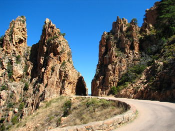 Panoramic view of rock formations against clear blue sky