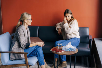 During a psychotherapy session a crying woman listens to the advice of a psychologist.