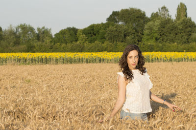 Portrait of young woman standing in field