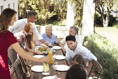 Happy family preparing lunch on garden table