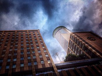 Low angle view of modern building against cloudy sky