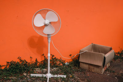 Old fan with electric cord in cardboard box, concept of power source, climate change