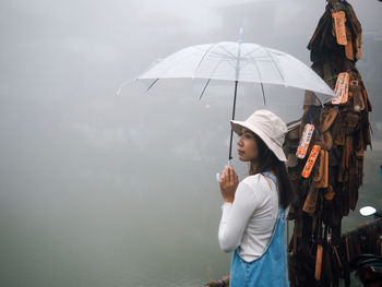 Rear view of woman holding umbrella