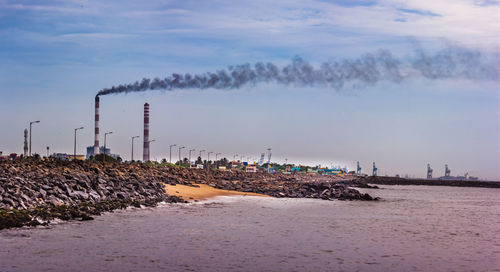 Smoke emitting from chimney against sky