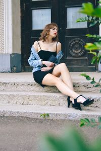 Full length of woman sitting outdoors