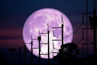 Low angle view of communications tower against sky at night