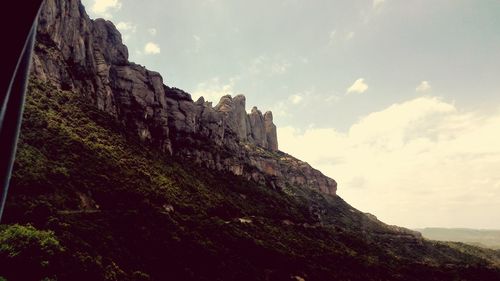 Low angle view of cliff against sky