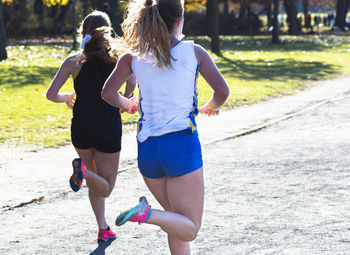 Rear view of women running on road