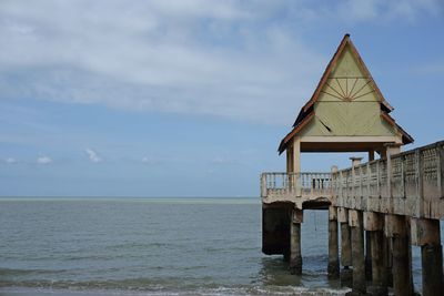 Lifeguard hut by sea against sky