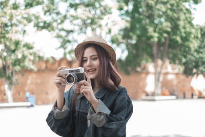 Portrait of young woman photographing